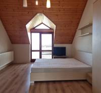 Attic room in a family house with wooden ceilings and a bed.
