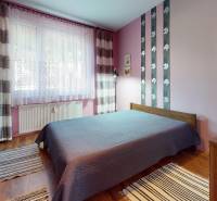 Bedroom in a 3-room apartment with colorful walls, a bed, and carpets.