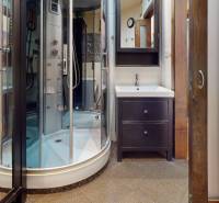 A bathroom in a 3-room apartment with a modern shower, sink, and washing machine.