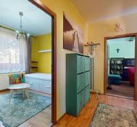 A hallway with doors to rooms and colorful furniture in a 3-room apartment.