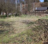 Land on Myslavská and Záhrady Street with grass, trees, and a cottage in the background.