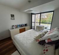 A bright bedroom in a 2-room apartment with a balcony and venetian blinds.