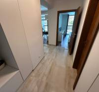 A hallway with tiles and built-in wardrobes in a 2-room apartment.