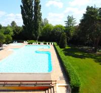An exterior with a pool and loungers surrounded by greenery on Rekračná Street in Piešťany.