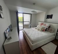 A bright bedroom in a 2-room apartment with a comfortable bed and balcony doors.