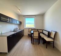 Kitchen in a 3-room apartment with a dining table and a view from the window.