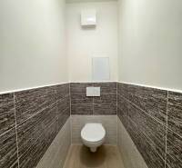 A toilet in a 3-room apartment, tiled with a spacious floor.