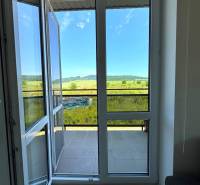 View from a 3-room apartment to the balcony and the landscape with a blue sky.