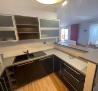 A kitchen in a 3-room apartment with wooden flooring and built-in appliances.