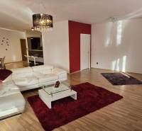 A spacious living room with a white sofa and a red carpet in a 3-room apartment.