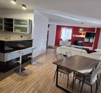 Spacious living room and kitchen with an island in a 3-room apartment with a dining table.
