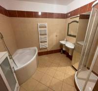 A bathroom in a 3-room apartment with a shower and a bathtub.