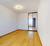 An empty room with a wooden floor and a large mirrored wardrobe, 2-room apartment.