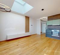 A kitchen in a 2-room apartment with wooden flooring and built-in appliances.