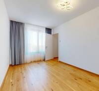 A spacious room with wooden flooring and curtains in a 2-room apartment.