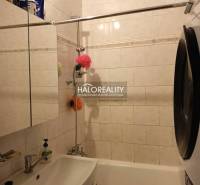 Bathroom in a 3-room apartment with a shower and a washing machine, elegant wall tiles.