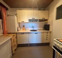 A cottage kitchen with white cabinets, a stove, and a sink.