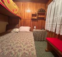 Wooden interior with a bed in a cabin, lace curtain, rustic atmosphere of tranquility.