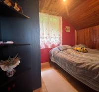 A room in a cottage with a wooden ceiling lining and decorative accessories.