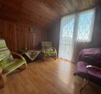 Wooden interior of a cabin with comfortable armchairs and glass doors with a view.