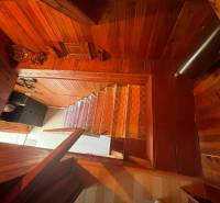 Wooden stairs with carpet in the interior of the cottage, decorative elements highlight the coziness.