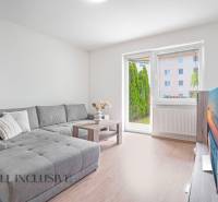 Living room with a corner sofa, television, and a view of the garden in a 2-room apartment.