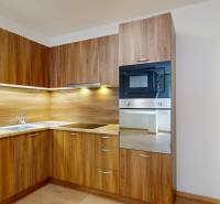 A kitchen unit in a wooden decor with an oven and a hob in a 2-room apartment.