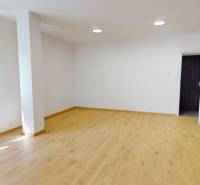 Spacious living room with wooden flooring and white walls in a 2-room apartment.