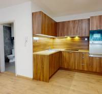 Interior of a 2-room apartment with a wooden kitchen unit and built-in appliances.