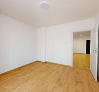 A room with a wooden floor and white walls in a 2-room apartment.