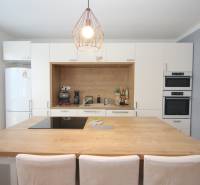 A kitchen in a 2-room apartment with built-in appliances and a bar counter.