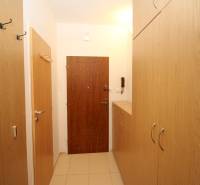 The entrance hall of a 2-room apartment with wooden furniture and tiled flooring.