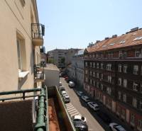 View from the balcony onto the street in Bratislava, Old Town, Medená, along a row of cars and buildings.