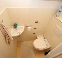 Compact bathroom with a sink, toilet, towel, and mat in a 2-room apartment.