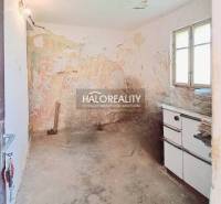 An abandoned room with old furniture and cracked walls in a family house.