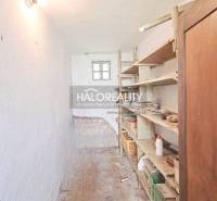 A narrow hallway with storage shelves in a family house in Norovce.
