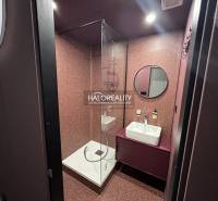 Hallway with a wardrobe and mirror in a studio apartment, light flooring and white walls.