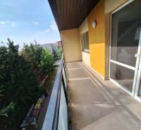 The balcony of a 4-room apartment in Prešov with a view of trees and the courtyard.