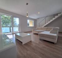 A bright living room with a white sofa and a staircase in a 4-room apartment.