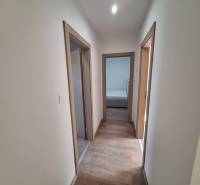 A hallway with wooden flooring and light-colored walls in a 4-room apartment.