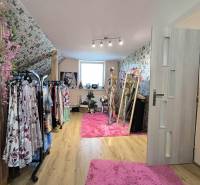 A dressing room in a family house with clothes hangers and a mirror on a pink carpet.