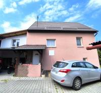 A family house in Nitrica with a driveway and a parked car in the yard.