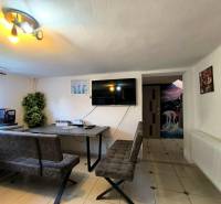 Dining room in a family house with a television, sofas, and interior decorations.