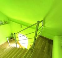 Light green staircase with wooden steps and decorations in a family house.