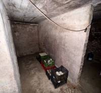 The basement of a family house with stored preserves and crates, part of a real estate agency's offer.