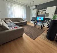 A living room in a family house with a comfortable sofa, modern furniture, and a television.