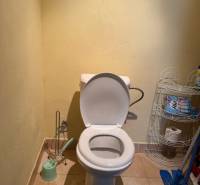 Bathroom in a family house with a toilet and a toilet paper holder.