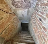 The staircase leading to the basement in a family house with brick walls.
