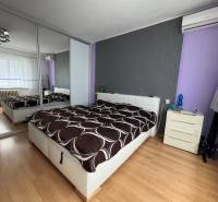 Bedroom in a family house with a bed and a mirrored wardrobe.