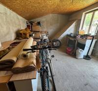 Attic storage space with a bicycle and cardboard boxes in a family house.